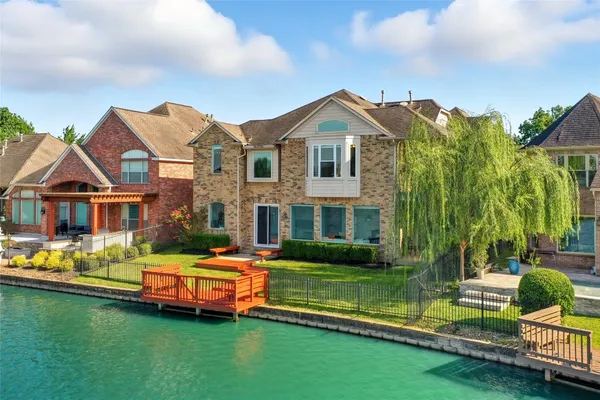 an aerial view of ocean and residential houses with outdoor space