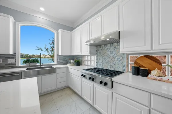 a kitchen with stainless steel appliances granite countertop a stove a sink and a white cabinets