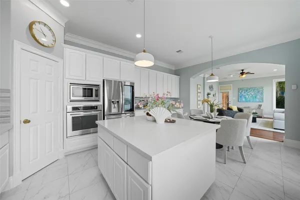 a kitchen with a sink a counter space appliances and cabinets