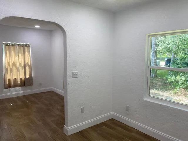 an empty room with wooden floor and mirror