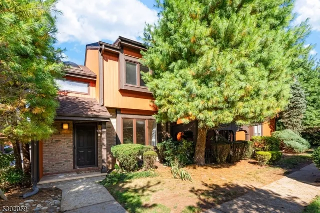 a front view of a house with a yard covered with snow