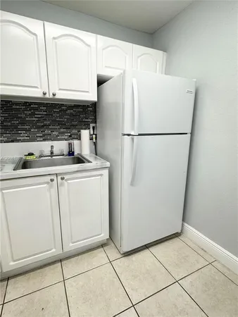 a white refrigerator freezer and a stove sitting inside of a kitchen