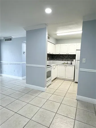 a kitchen with granite countertop a stove a sink and a refrigerator