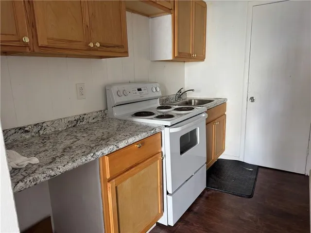 a white stove top oven sitting inside of a kitchen