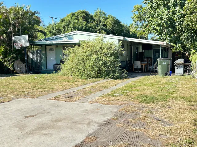 a view of a house with floor to ceiling windows and a yard