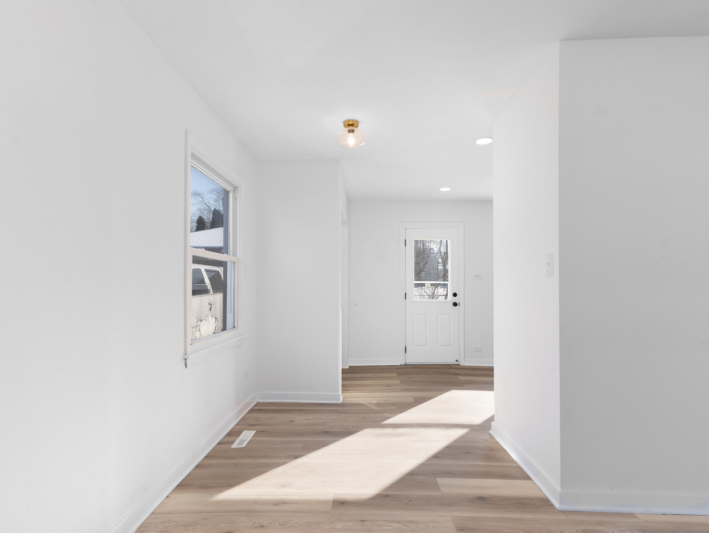 1917 Linden Avenue Hanover Park, IL 60133 - Photo 10 of 22 a view of a hallway with wooden floor and a bathroom