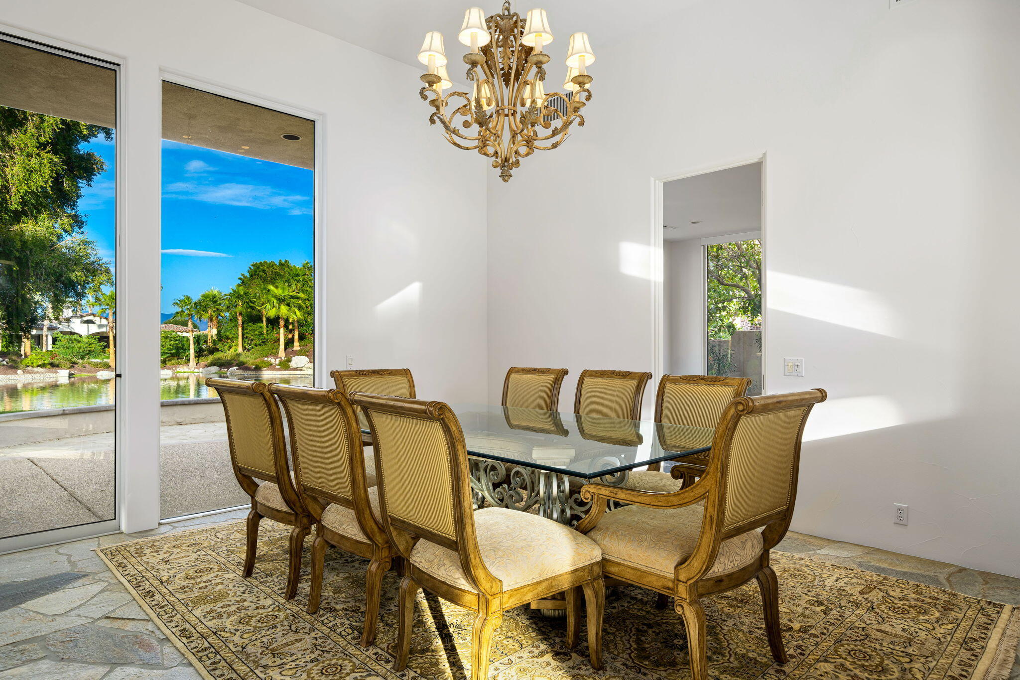 55770 Cherry Hills Drive La Quinta, CA 92253 - Photo 22 of 43 a view of a dining room with furniture a potted plant and a chandelier