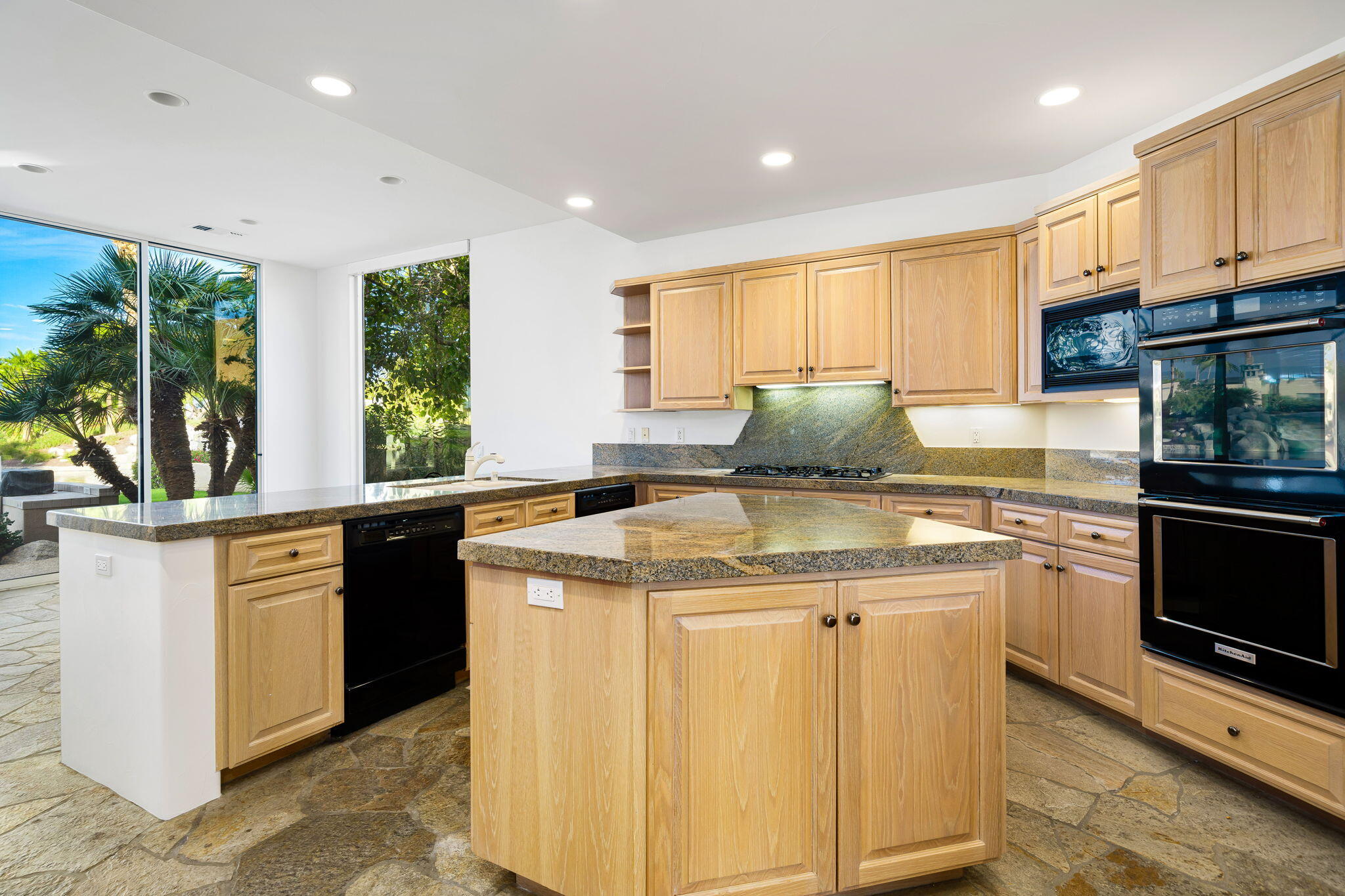 55770 Cherry Hills Drive La Quinta, CA 92253 - Photo 26 of 43 a kitchen with stainless steel appliances granite countertop a stove a sink and a microwave