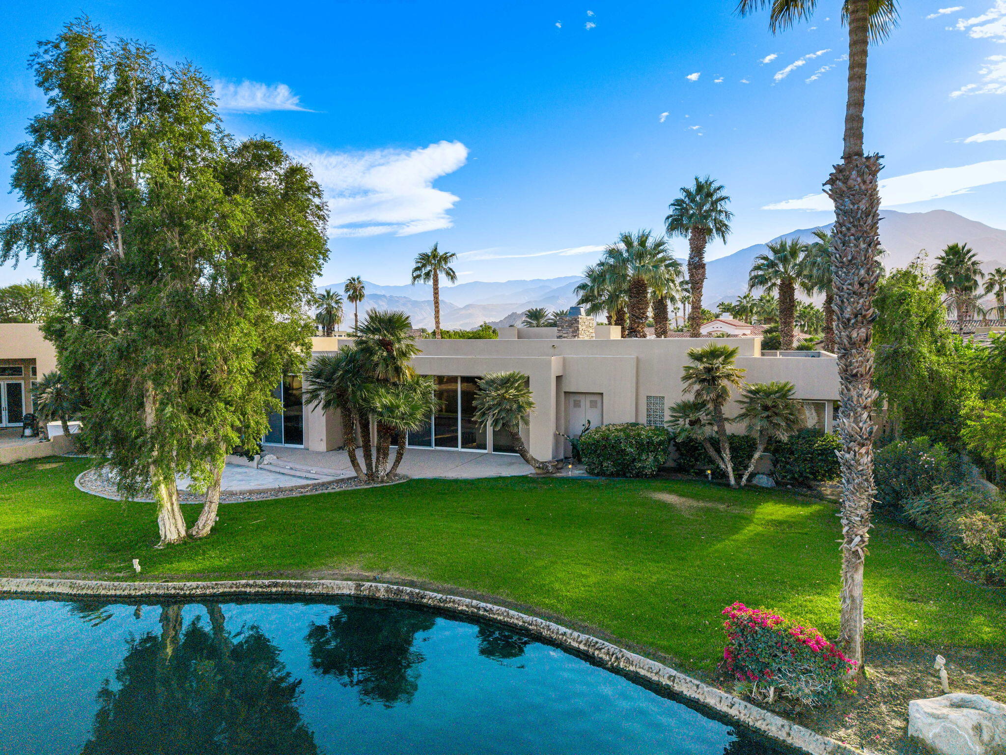 55770 Cherry Hills Drive La Quinta, CA 92253 - Photo 6 of 43 a view of a garden with a building in the background