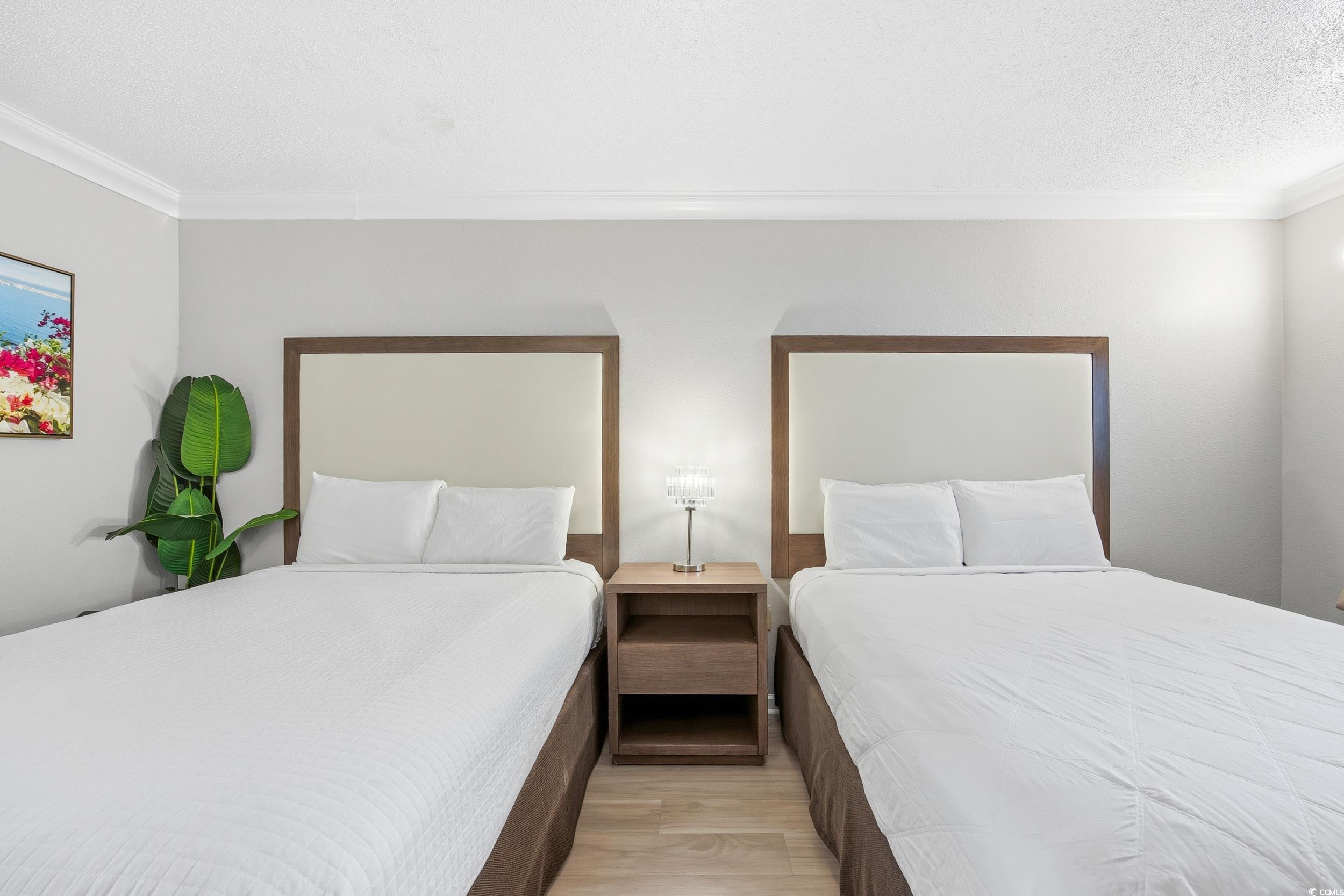 1105 South Ocean Boulevard, Unit 932 Myrtle Beach, SC 29577 - Photo 9 of 32 Bedroom with ornamental molding, light wood-style flooring, and a textured ceiling