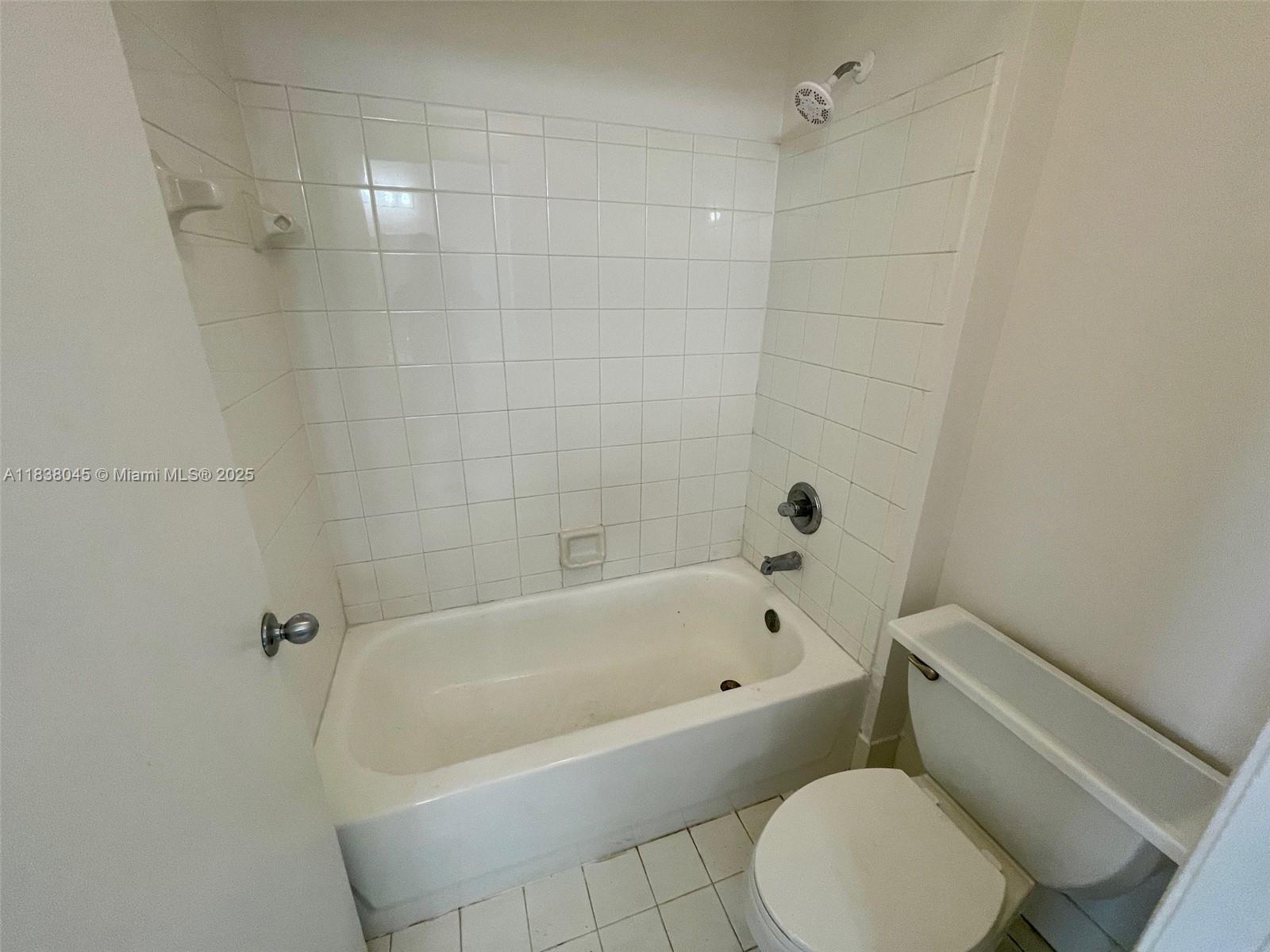 6984 Southwest 39th Street, Unit H202 Davie, FL 33314 - Photo 11 of 17 a white bath tub sitting next to a white toilet and sink