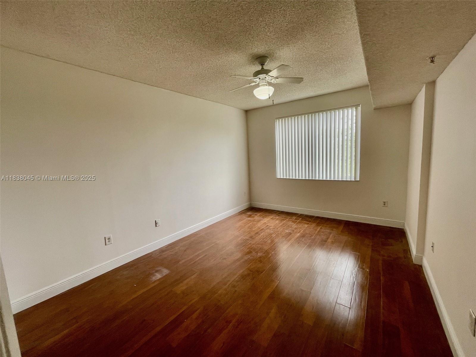 6984 Southwest 39th Street, Unit H202 Davie, FL 33314 - Photo 13 of 17 an empty room with wooden floor and windows