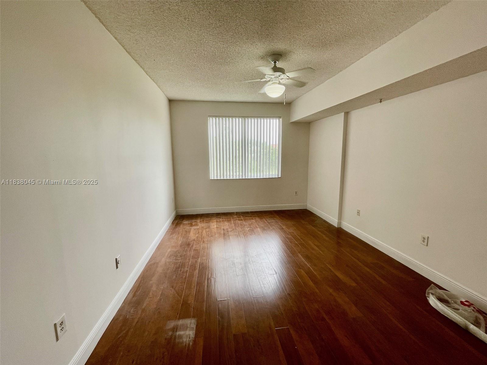 6984 Southwest 39th Street, Unit H202 Davie, FL 33314 - Photo 14 of 17 a view of an empty room with wooden floor and a window