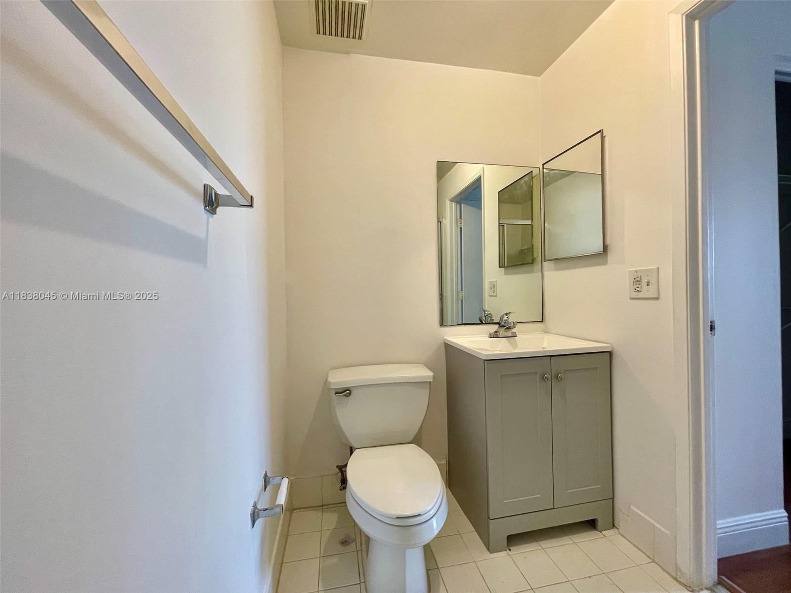6984 Southwest 39th Street, Unit H202 Davie, FL 33314 - Photo 16 of 17 a bathroom with a toilet sink and mirror