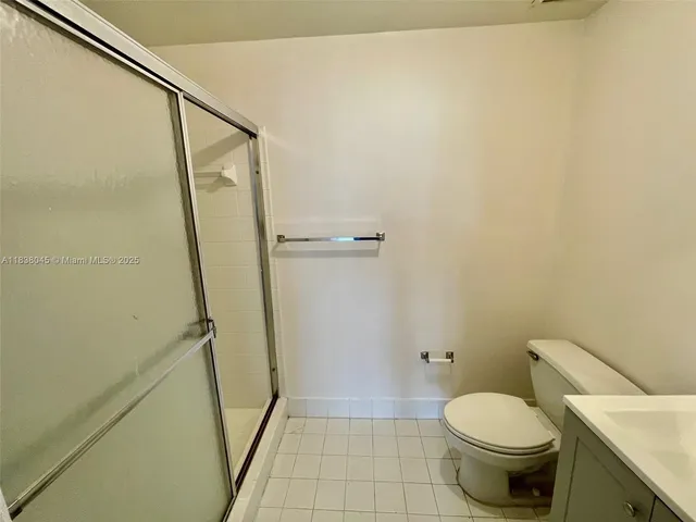 a bathroom with a granite countertop toilet and a shower