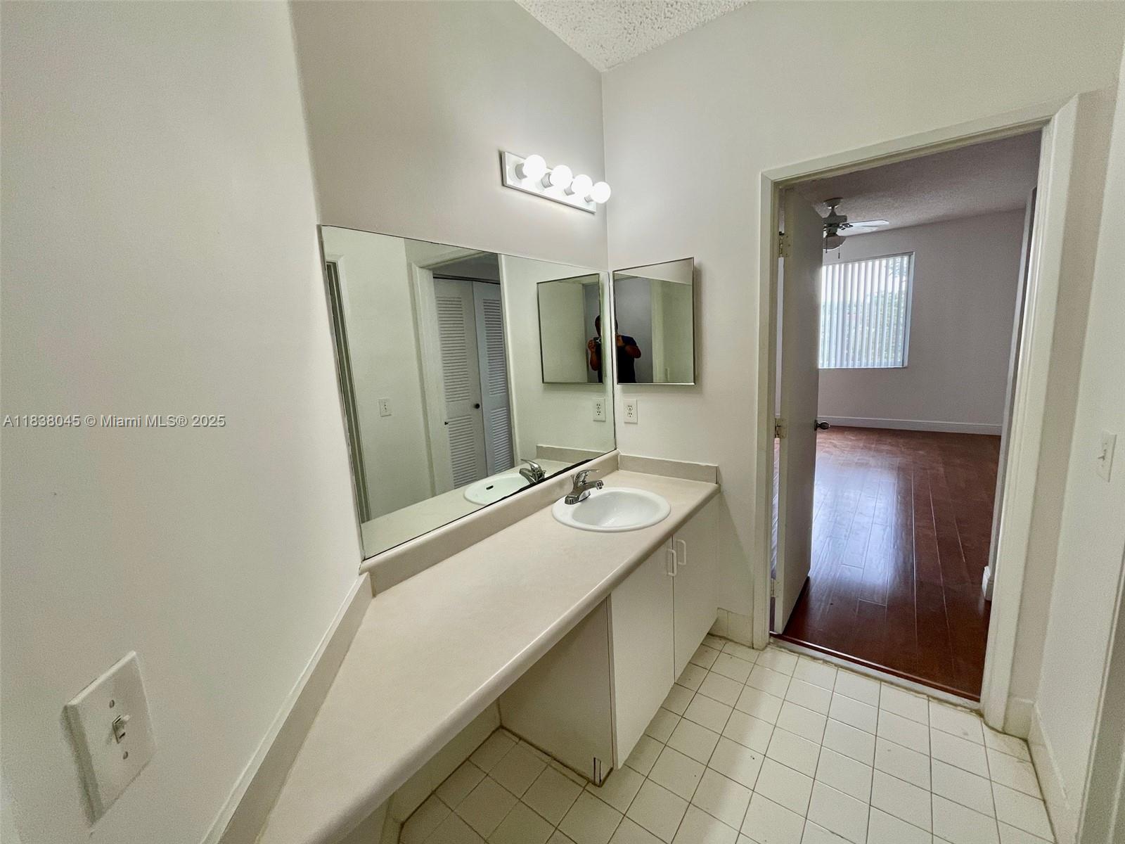 6984 Southwest 39th Street, Unit H202 Davie, FL 33314 - Photo 9 of 17 a bathroom with a tub sink and mirror