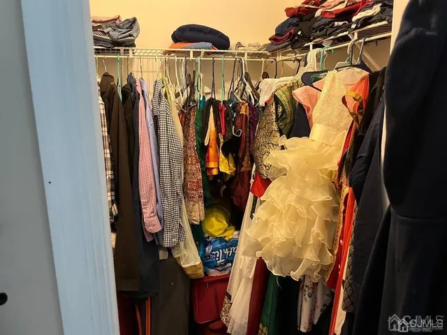 a view of walk in closet with clothes and shoes