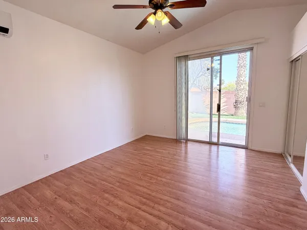 a view of an empty room with wooden floor and a window