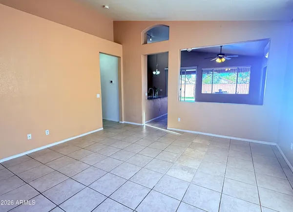 an empty room with windows and ceiling fan