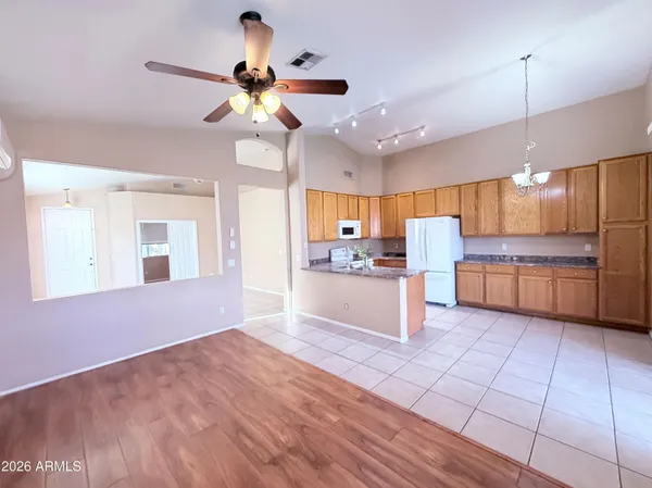 a view of kitchen with granite countertop cabinets and refrigerator
