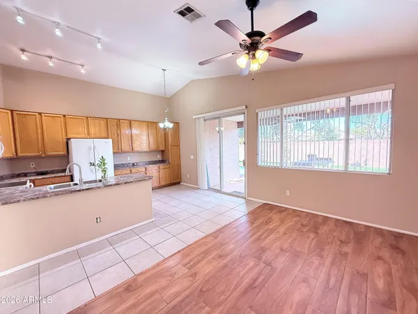 a kitchen with granite countertop a stove a sink and a refrigerator
