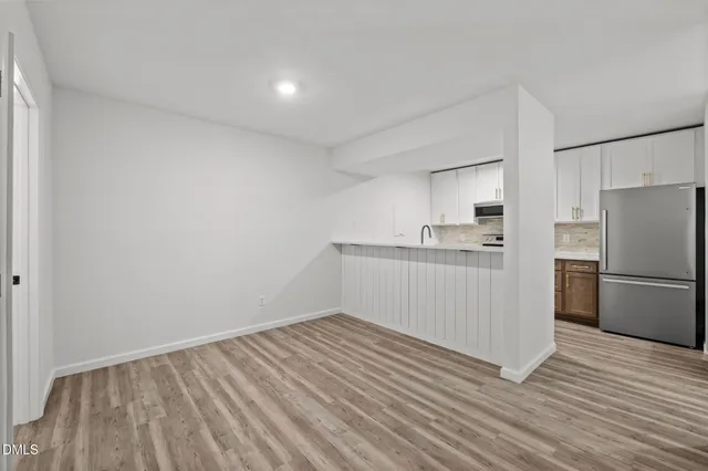 a kitchen with a refrigerator and white cabinets