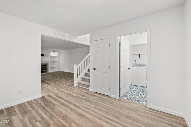 a view of a hallway with wooden floor and entryway