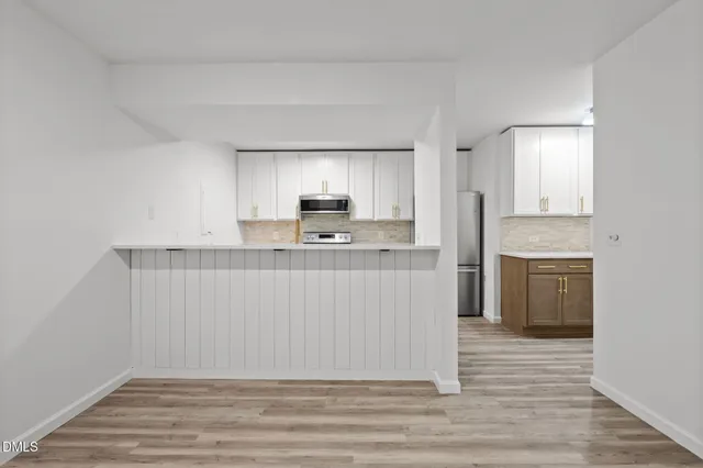 a view of a room with a chandelier fan and wooden floor
