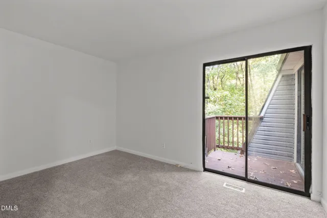 an empty room with sliding door and windows