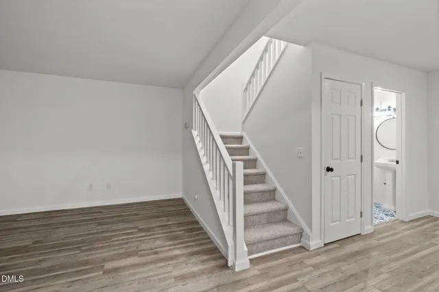 a view of a hallway with wooden floor and entryway