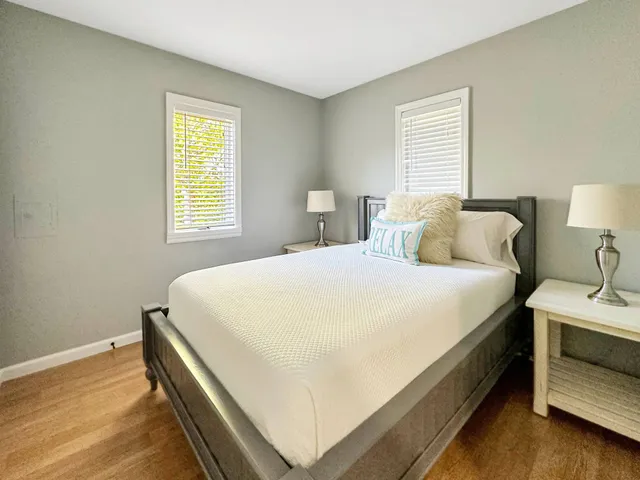 a large bed sitting in a bedroom next to a window and a lamp