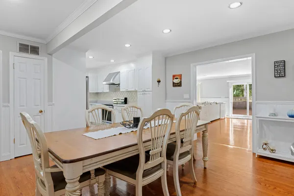 a kitchen with a dining table chairs and wooden floor