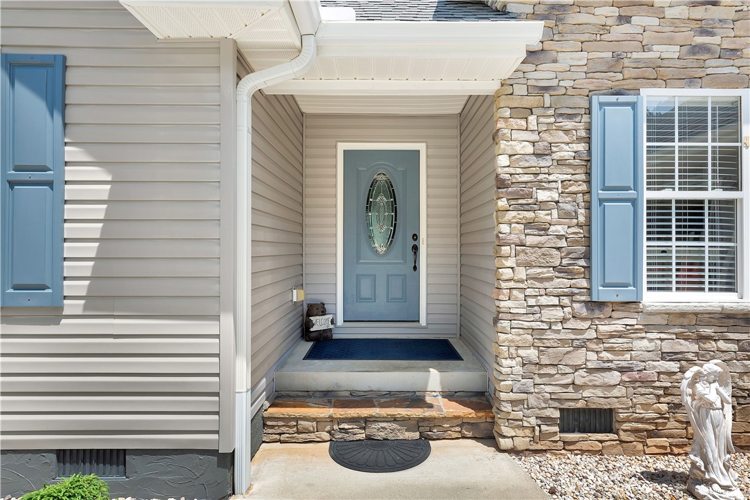 131 Morgan Road West Union, SC 29696 - Photo 27 of 39 A welcoming entry features a paneled front door with decorative glass, flanked by blue shutters and stone accents.