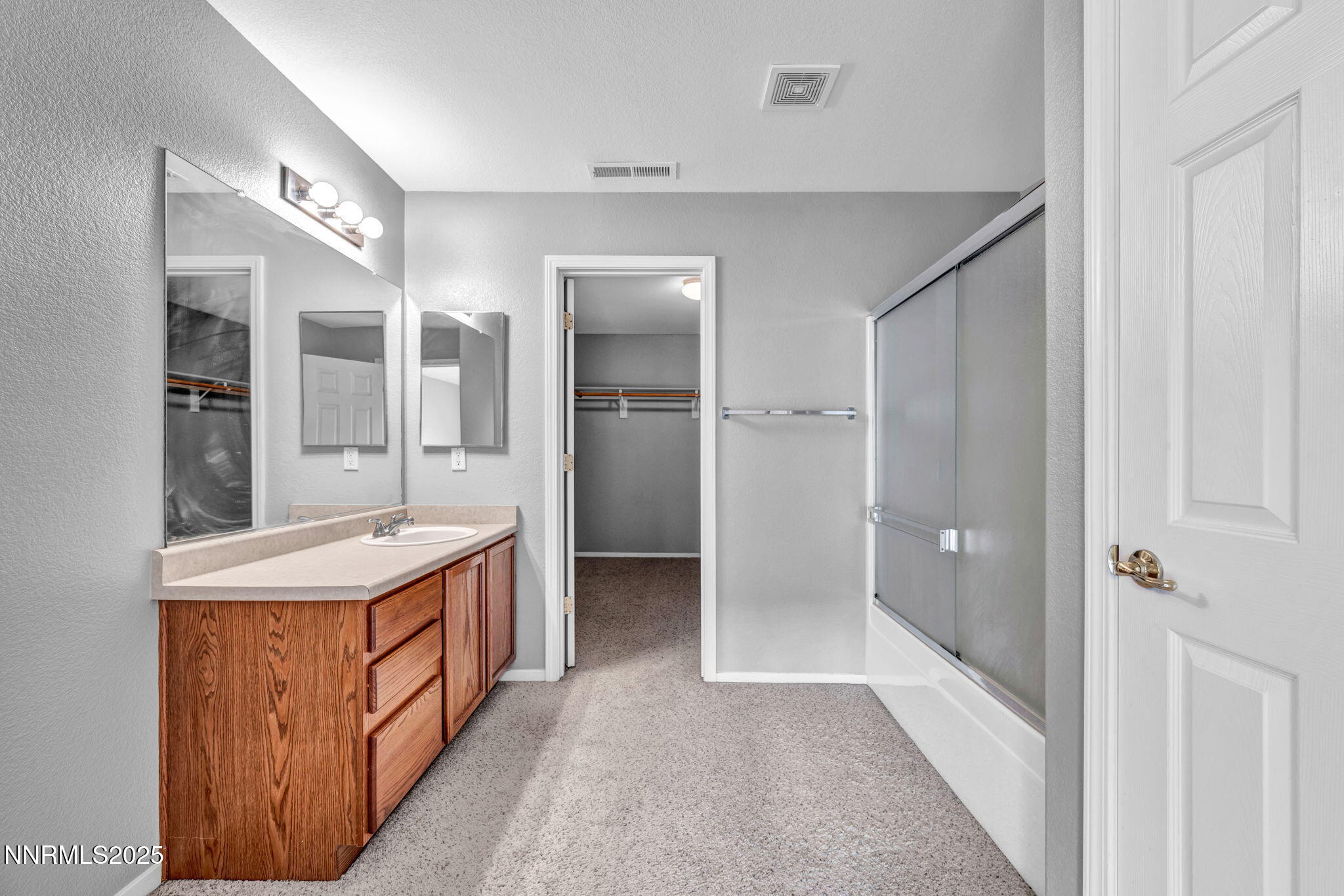 7644 Corso Street Reno, NV 89506 - Photo 29 of 54 a bathroom with a sink a mirror and a shower