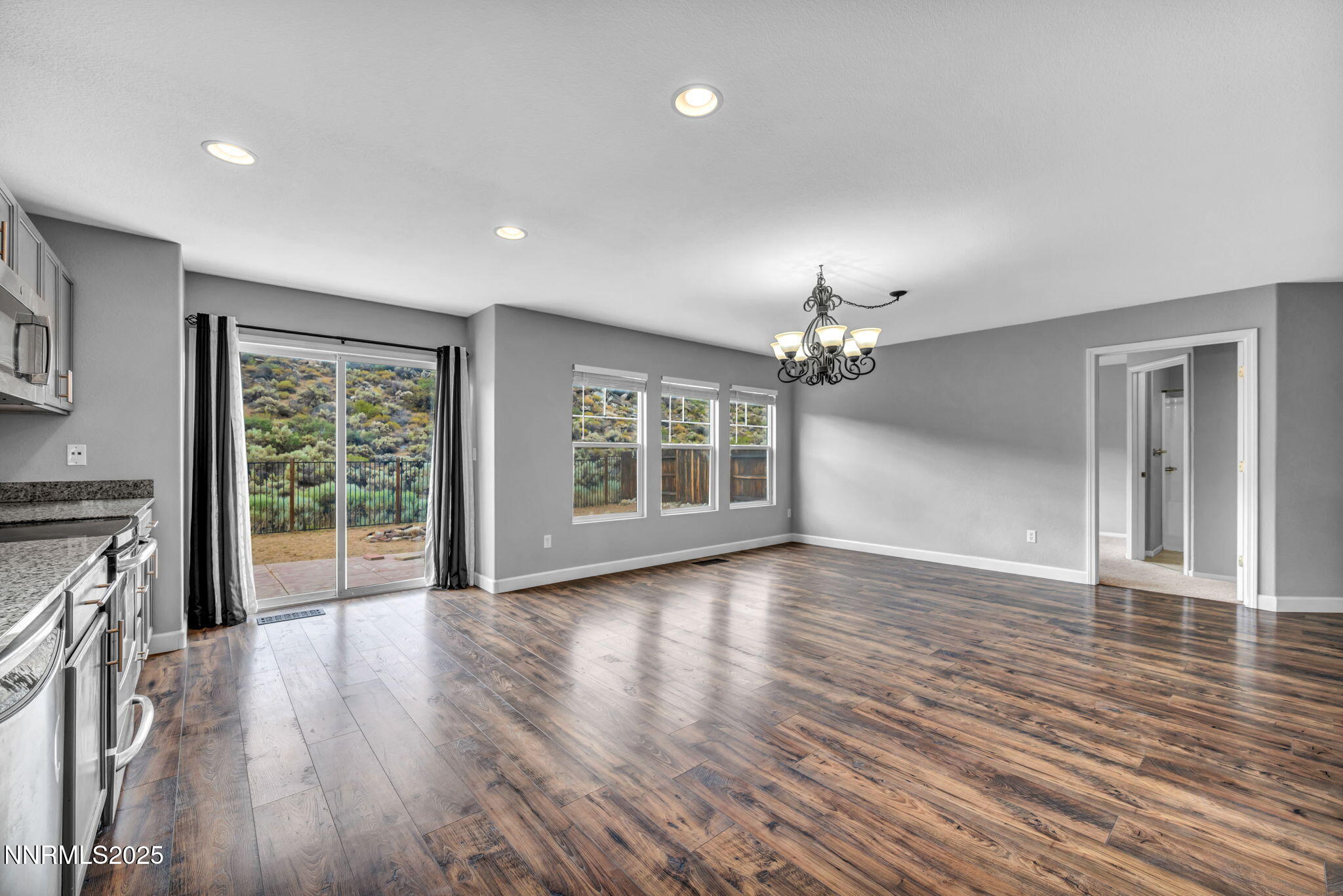 7644 Corso Street Reno, NV 89506 - Photo 39 of 54 a view of a livingroom with wooden floor a ceiling fan and windows