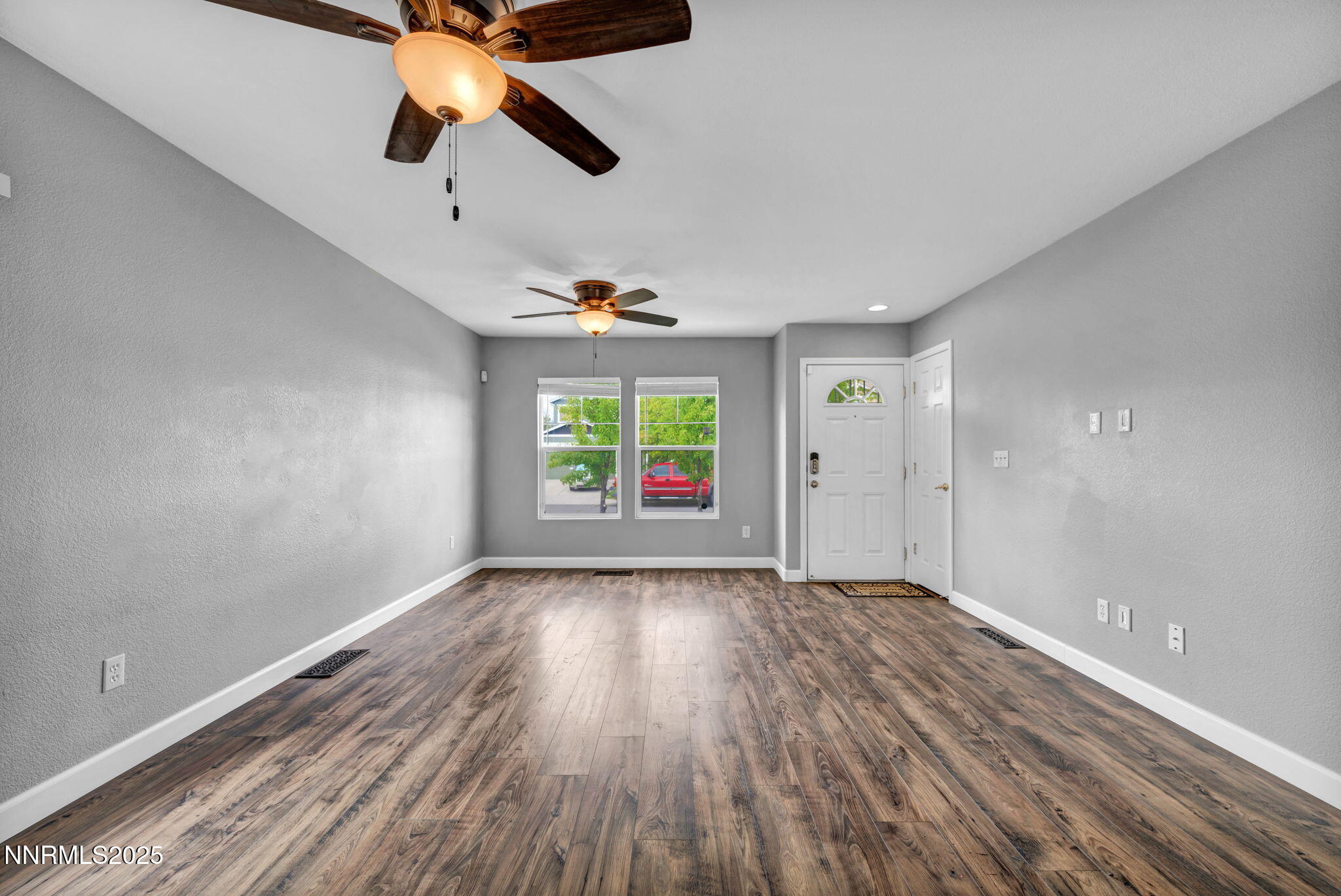 7644 Corso Street Reno, NV 89506 - Photo 46 of 54 an empty room with wooden floor ceiling fan and windows