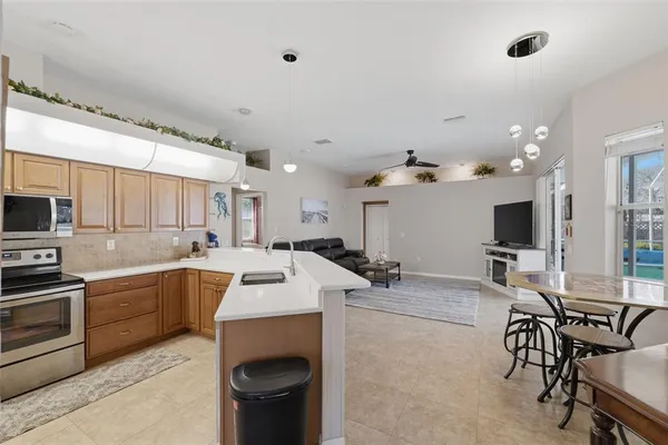 a view of kitchen with stainless steel appliances a white stove top oven and a refrigerator with wooden floor