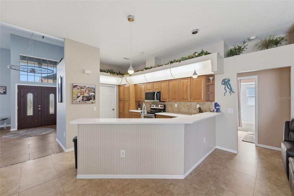 7442 Aloe Drive Spring Hill, FL 34607 - Photo 15 of 59 a view of kitchen with stainless steel appliances a white stove top oven and a refrigerator with wooden floor