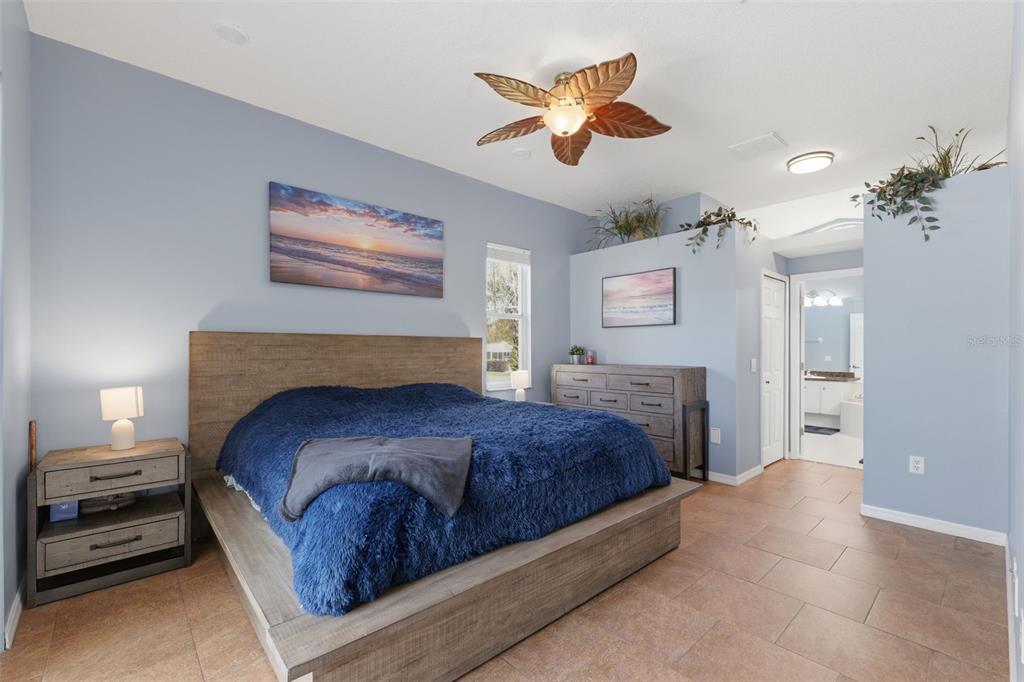 7442 Aloe Drive Spring Hill, FL 34607 - Photo 25 of 59 a bedroom with a bed and a chandelier