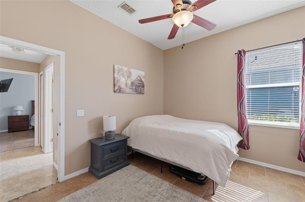 7442 Aloe Drive Spring Hill, FL 34607 - Photo 34 of 59 a bedroom with a bed and a chandelier