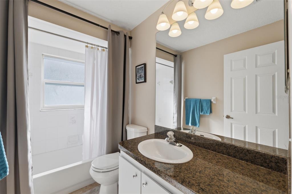 7442 Aloe Drive Spring Hill, FL 34607 - Photo 36 of 59 a bathroom with a granite countertop sink toilet and a mirror