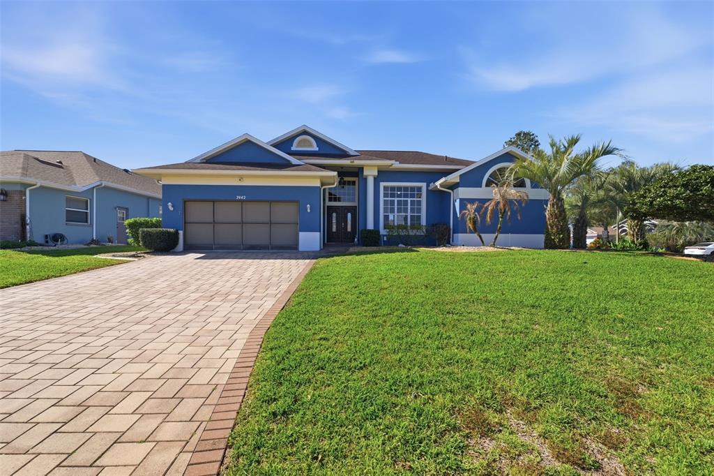 7442 Aloe Drive Spring Hill, FL 34607 - Photo 4 of 59 a front view of a house with a yard and potted plants
