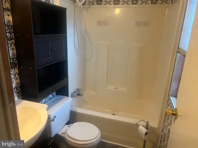 a bathroom with a toilet a sink and bathtub