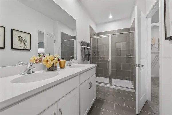 a bathroom with a shower sink and mirror