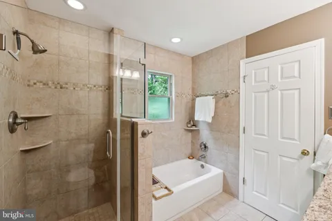 a bathroom with a tub a sink and a shower