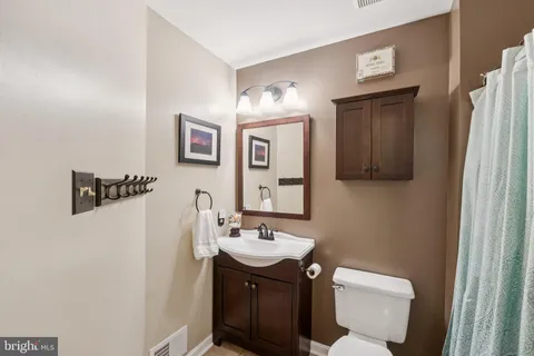 a bathroom with a toilet sink and mirror