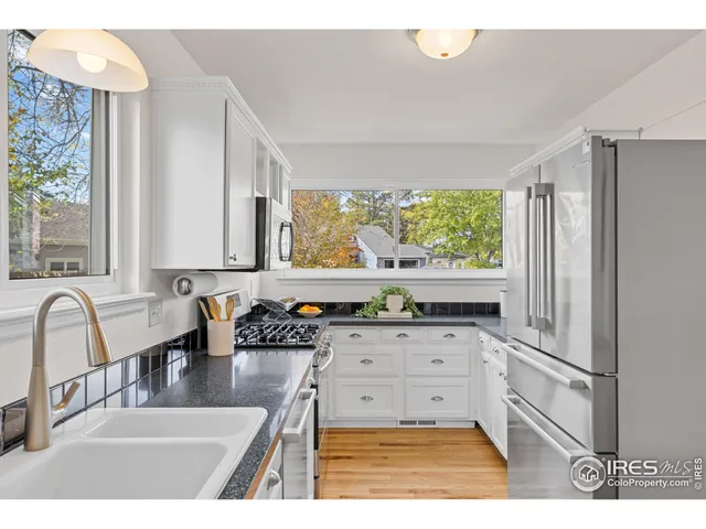 a kitchen with stainless steel appliances granite countertop a sink a stove and a refrigerator