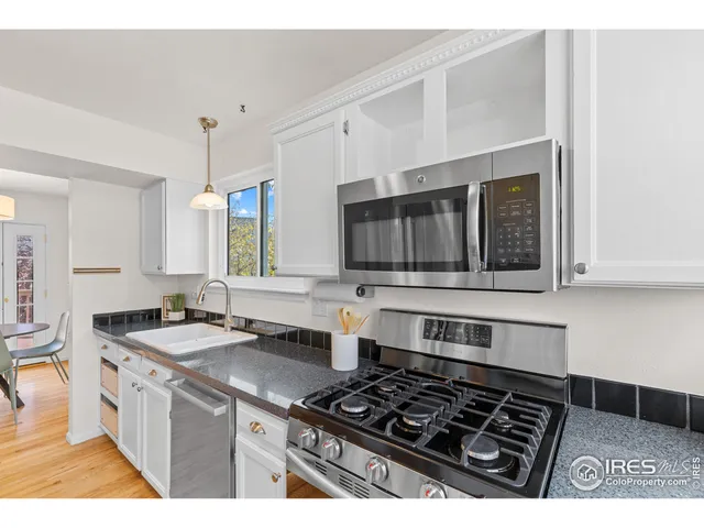 a kitchen with stainless steel appliances a stove a sink and a microwave
