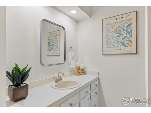 a bathroom with a sink a mirror and a potted plant