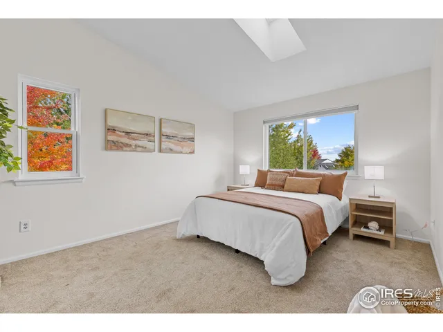 a bedroom with a bed and painting on the wall